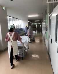 写真：給食を教室へ運んでいる様子