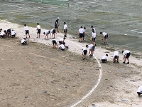 写真：校庭の雑草を取る生徒たち