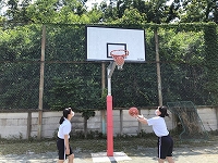写真：バスケットゴールネットを調整するバスケットボール部員
