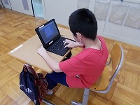 写真：タブレット端末を使う児童