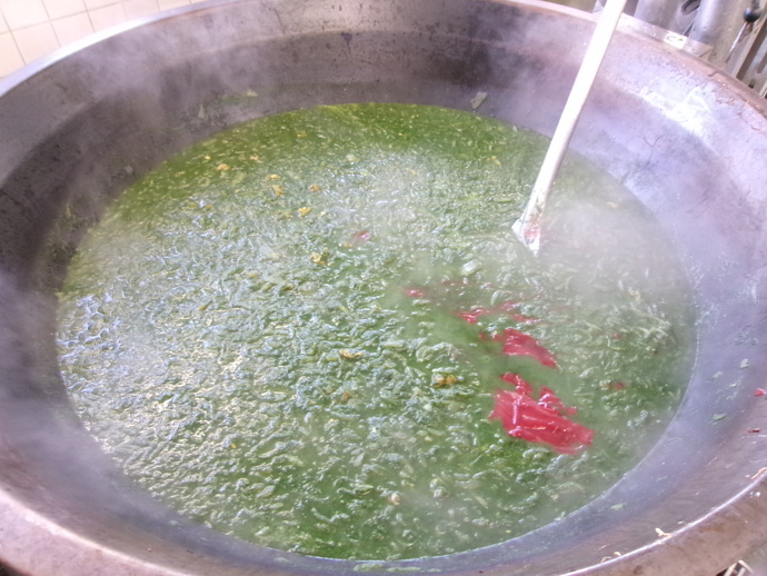 ほうれん草ピューレをスープと煮て、カレーを作っている様子